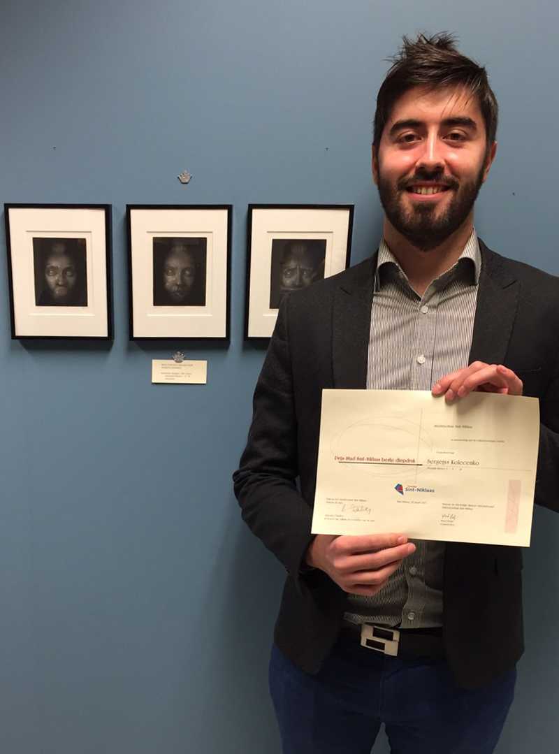 Sergejs Kolecenko is stading with diploma for best printmaking works in intaglio technique in front of his mezzotint artworks titled Silence