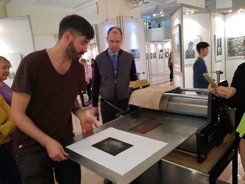 Sergejs Kolecenko Printed mezzotint work titled Blind and showing it to Dmitry Frolov at workshop in Salekhard, Russia 2019