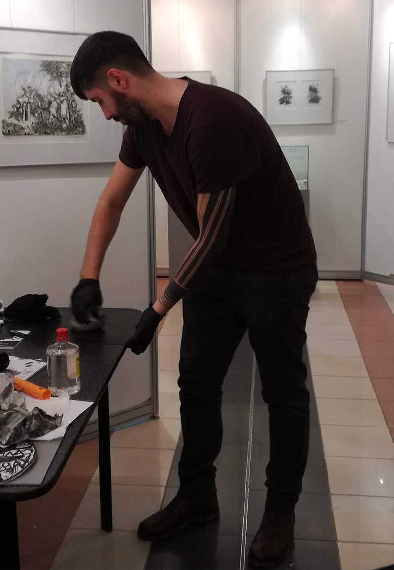 Sergejs Kolecenko showing students mezzotint inking process at workshop in Salekhard, Russia 2019